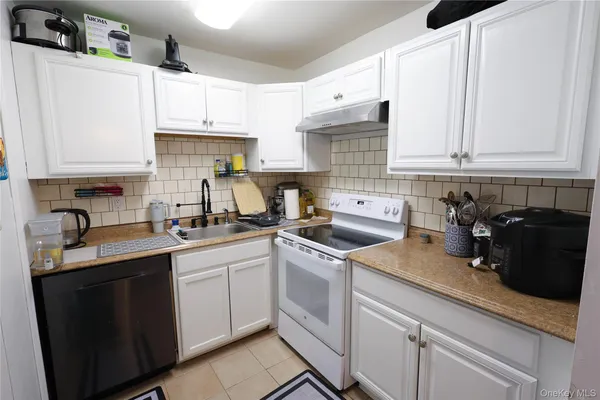 a kitchen with white cabinets and white appliances