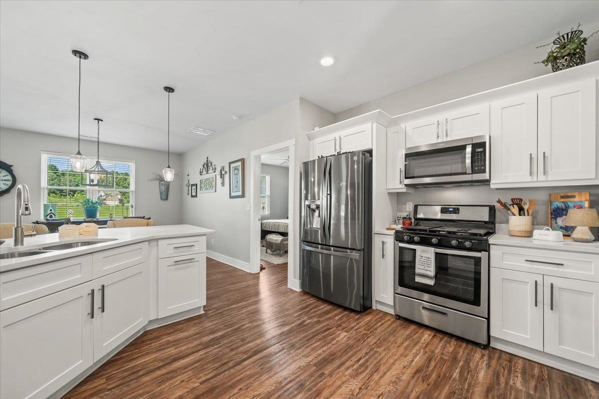 415 Abbey Road, Unit D Munford, TN 38058 - Photo 16 of 35 Modern kitchen featuring white cabinetry, stainless steel appliances, and wood-finish flooring