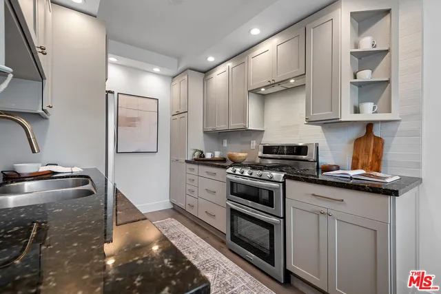a kitchen with stainless steel appliances granite countertop a stove a sink and a refrigerator
