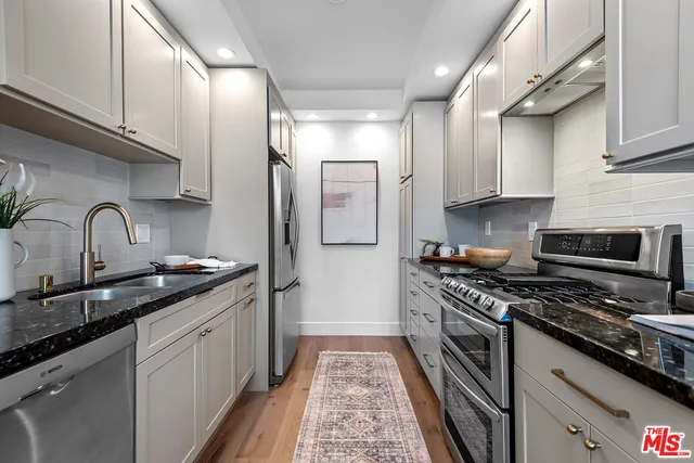 a kitchen with stainless steel appliances granite countertop a sink stove and refrigerator