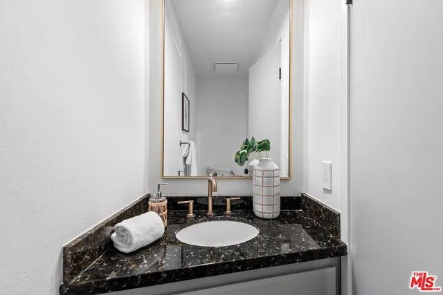 a bathroom with a granite countertop sink and a mirror