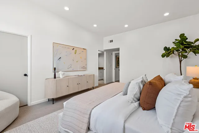 a bedroom with a bed and a painting on the wall