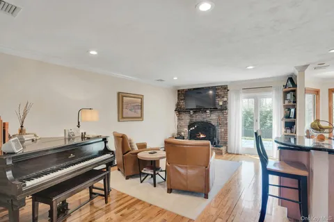 a living room with furniture a piano and a flat screen tv