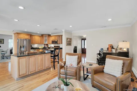 a living room with furniture kitchen and a wooden floor