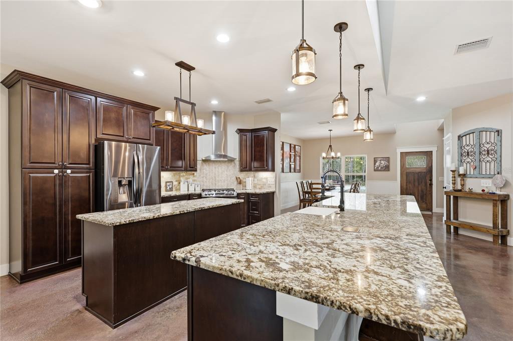 357 Southwest Conestoga Way Fort White, FL 32038 - Photo 13 of 44 a kitchen with stainless steel appliances kitchen island granite countertop a table and chairs in it