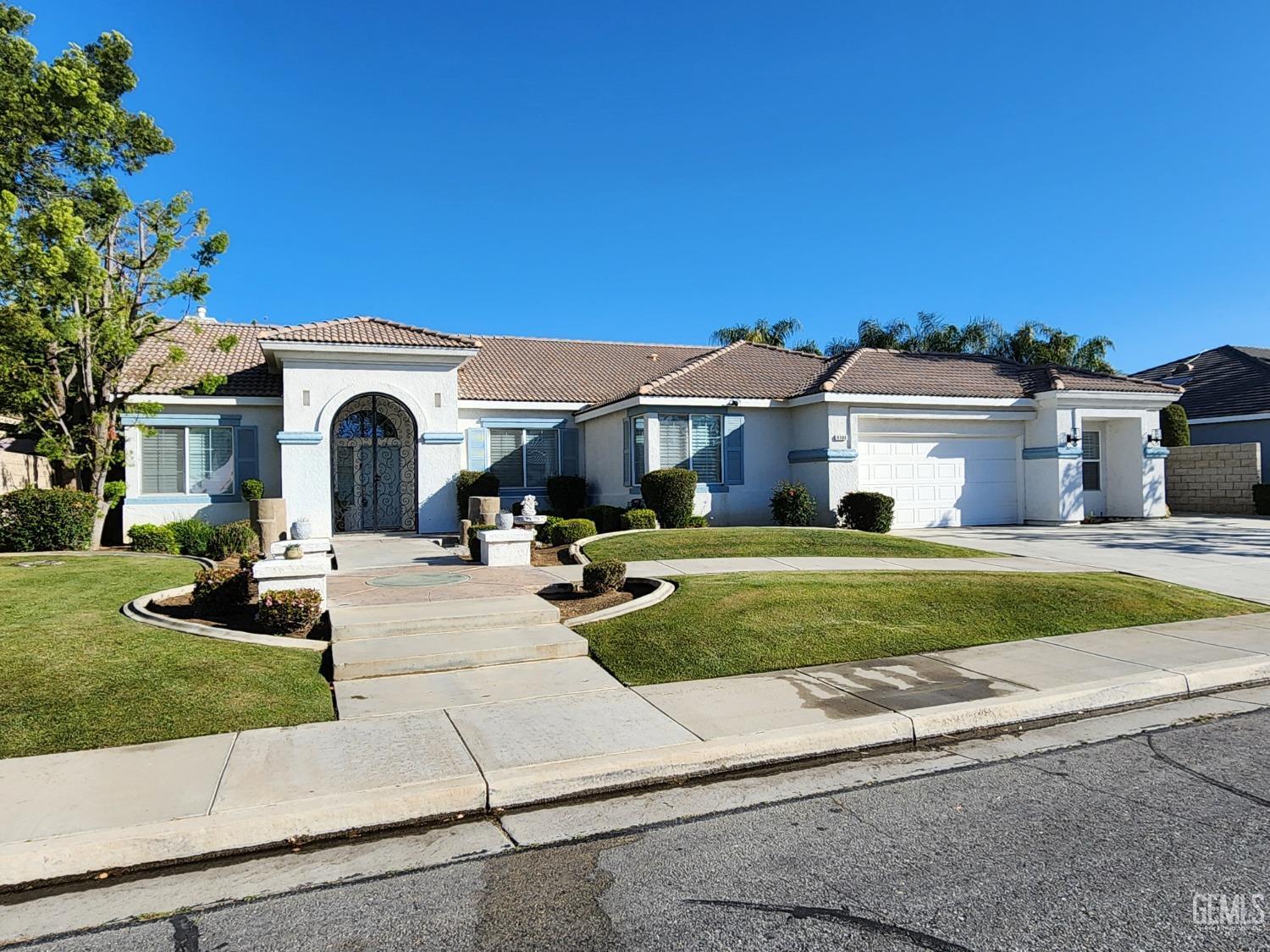 Undisclosed Address Bakersfield, CA 93312 - Photo 8 of 44 a view of a white house with a big yard plants and large trees