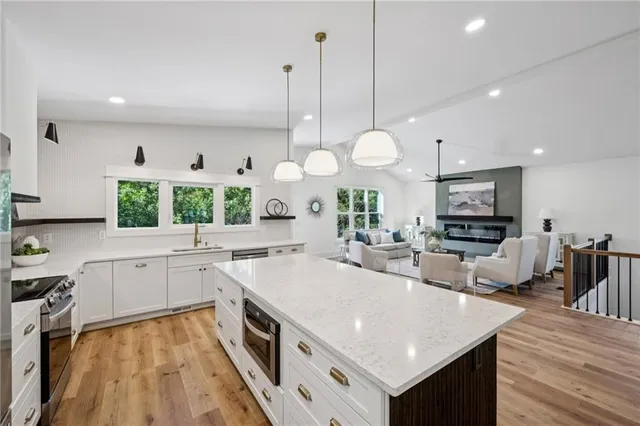 a kitchen with stainless steel appliances granite countertop a sink and a wooden floors
