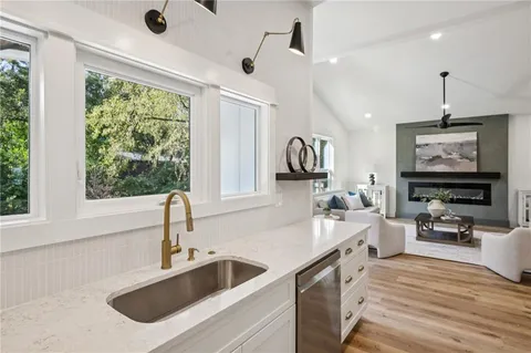a living room with fireplace furniture and a large window