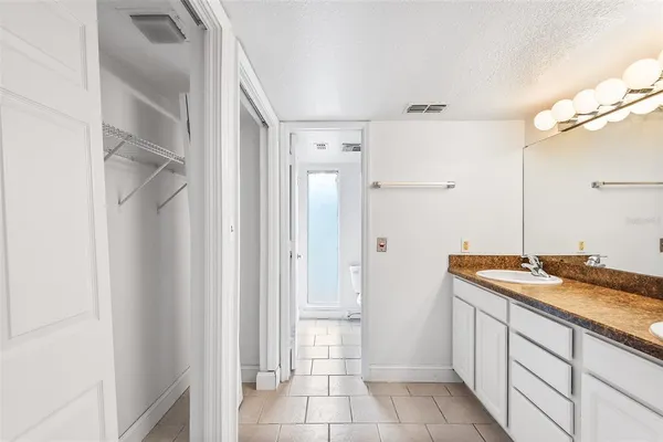a spacious bathroom with a granite countertop sink and a mirror