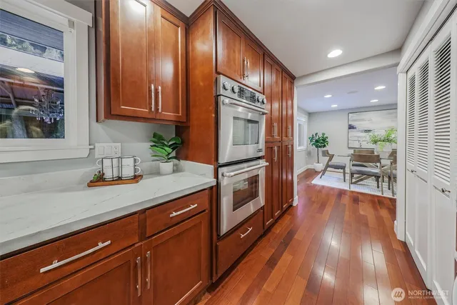 a kitchen with granite countertop wooden floors and stainless steel appliances