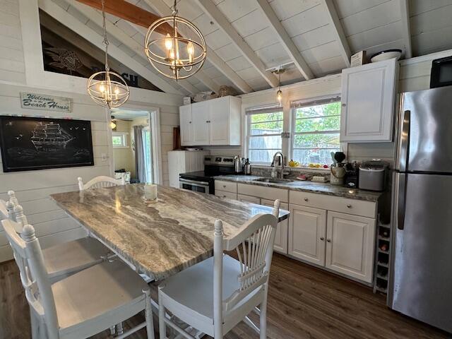 242 Old Wharf Road, Unit F7 Dennis Port, MA 02639 - Photo 15 of 48 a kitchen with stainless steel appliances granite countertop a stove a sink dishwasher a refrigerator with a dining table and chairs with wooden floor