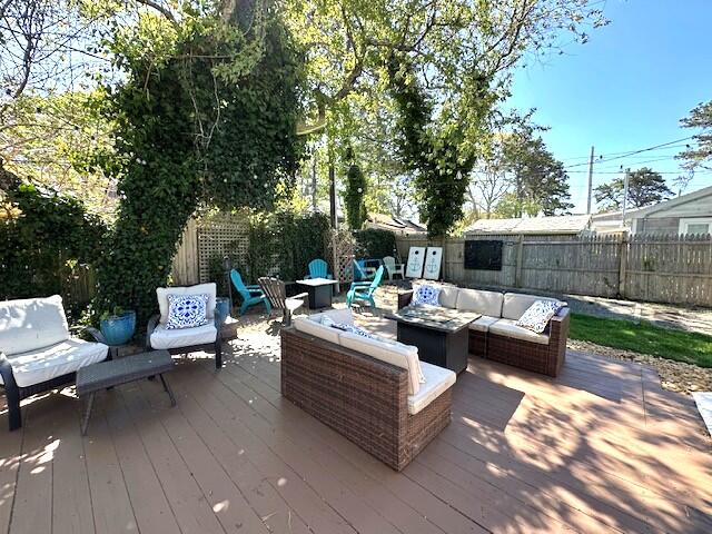 242 Old Wharf Road, Unit F7 Dennis Port, MA 02639 - Photo 8 of 48 a view of a patio with couches and a table and chairs with wooden floor and fence
