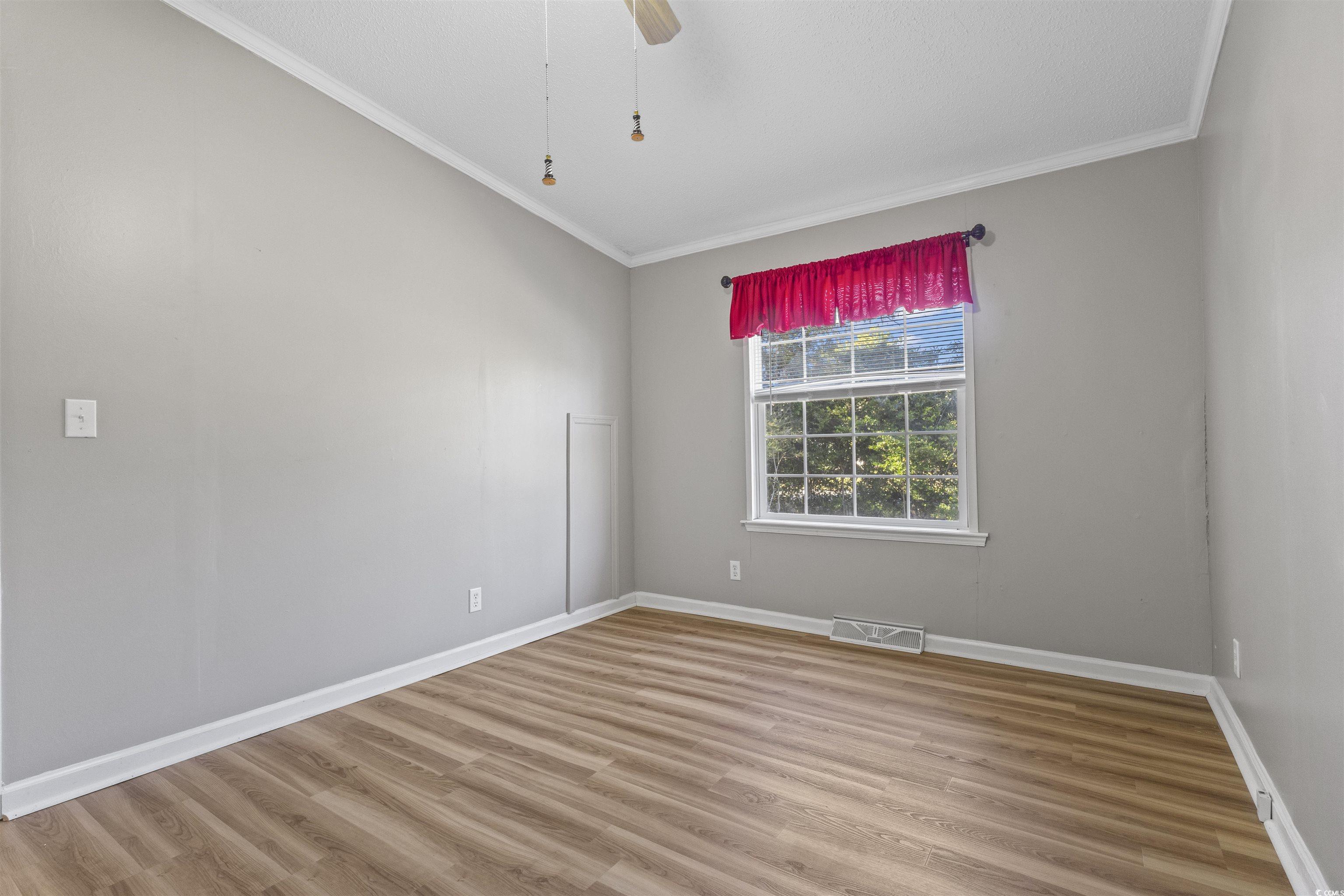 48 Talon Circle Murrells Inlet, SC 29576 - Photo 14 of 28 Spare room featuring light wood-type flooring, ornamental molding, and a ceiling fan