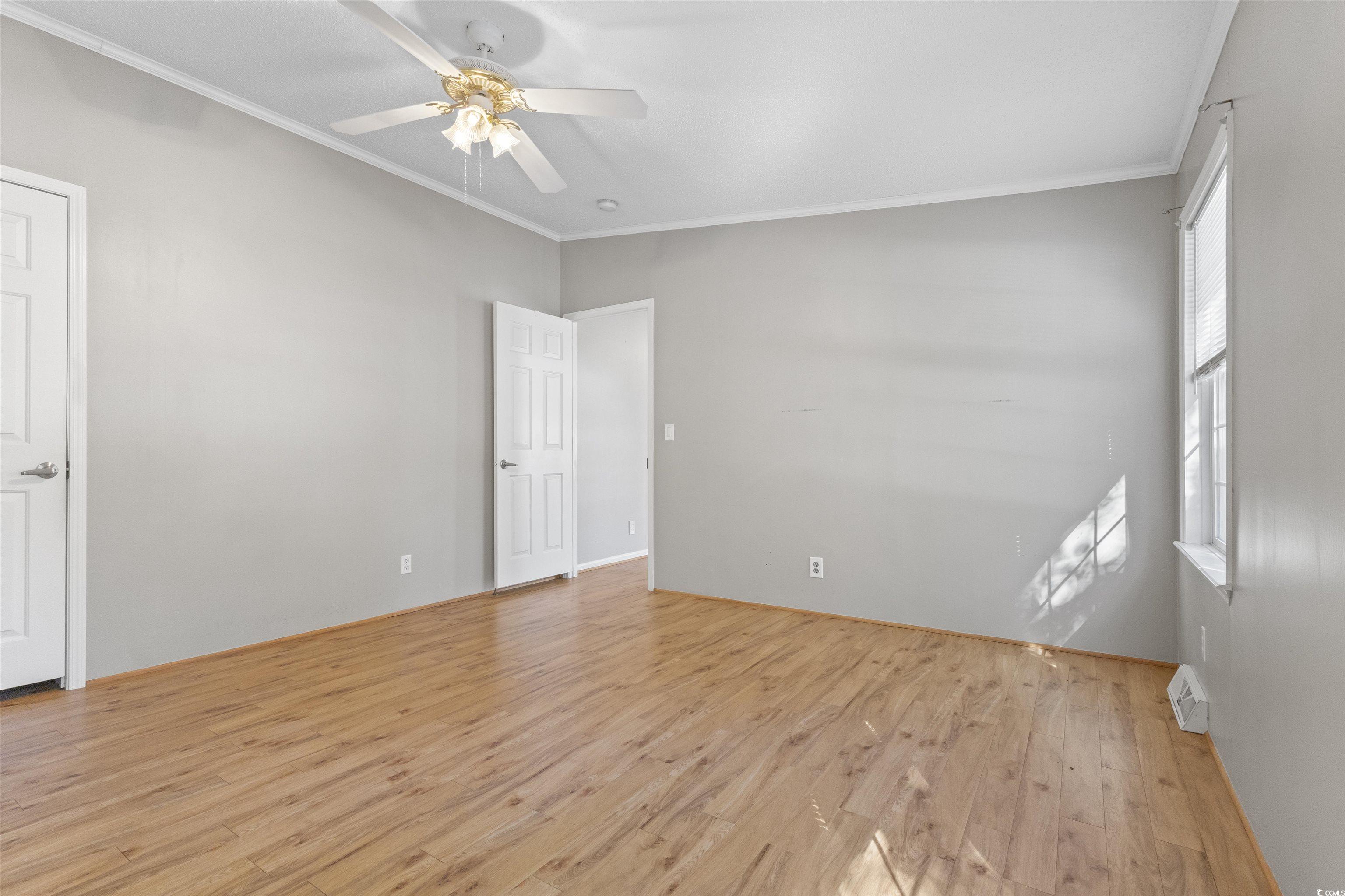 48 Talon Circle Murrells Inlet, SC 29576 - Photo 16 of 28 Empty room with light wood-style flooring, crown molding, and a ceiling fan