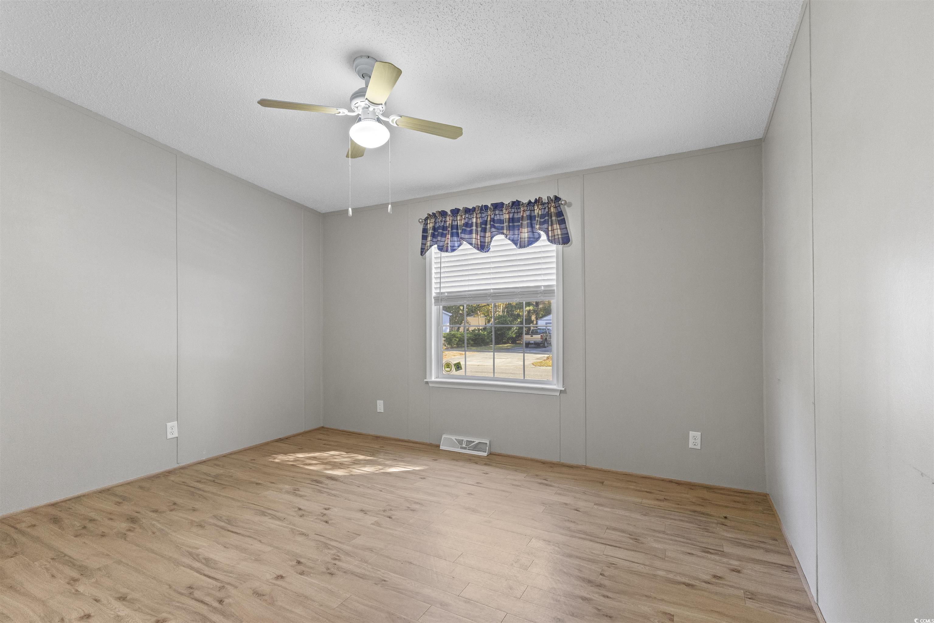 48 Talon Circle Murrells Inlet, SC 29576 - Photo 21 of 28 Unfurnished room featuring light wood finished floors, a textured ceiling, and ceiling fan