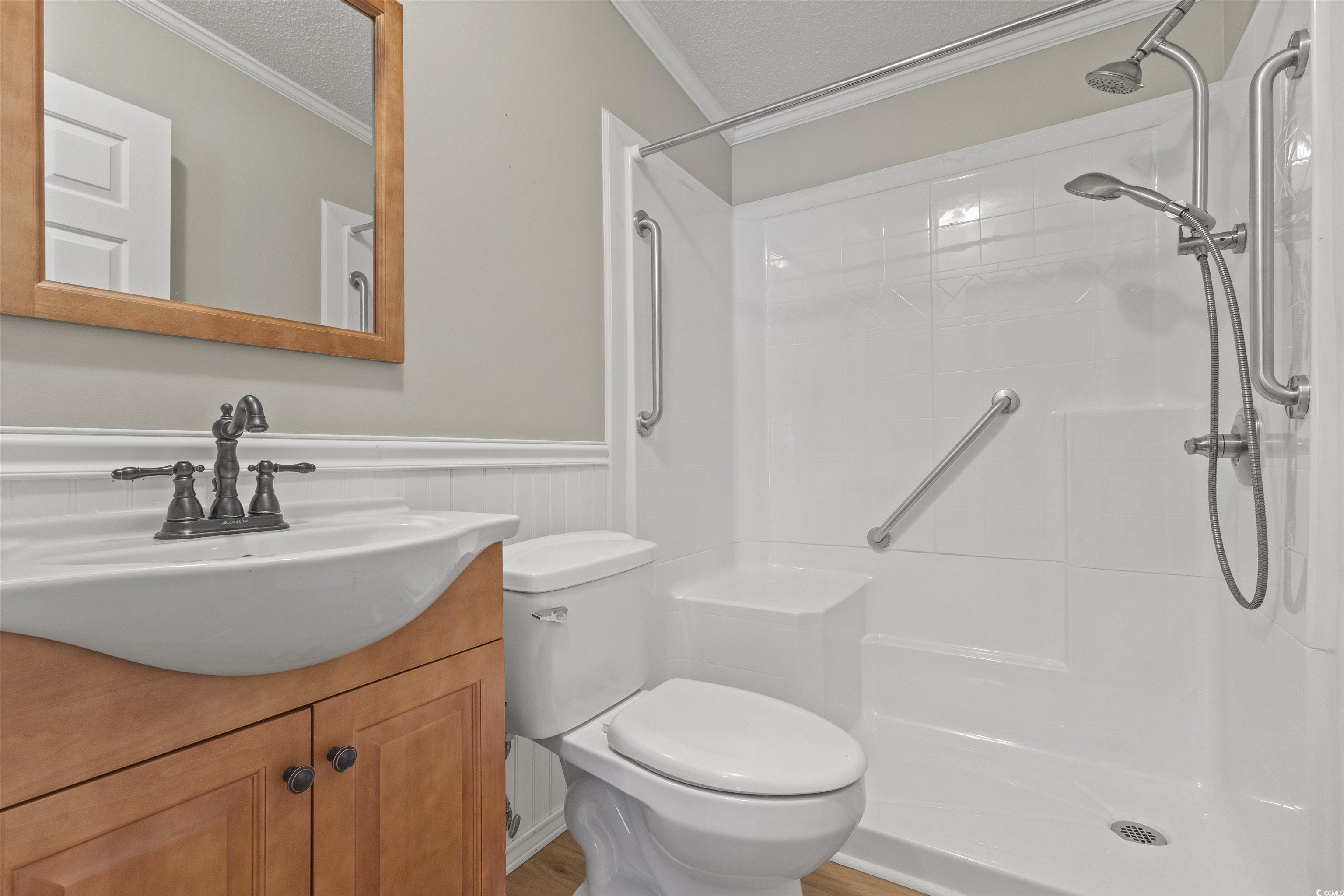 48 Talon Circle Murrells Inlet, SC 29576 - Photo 22 of 28 Bathroom with crown molding, a wainscoted wall, vanity, a shower, and a textured ceiling
