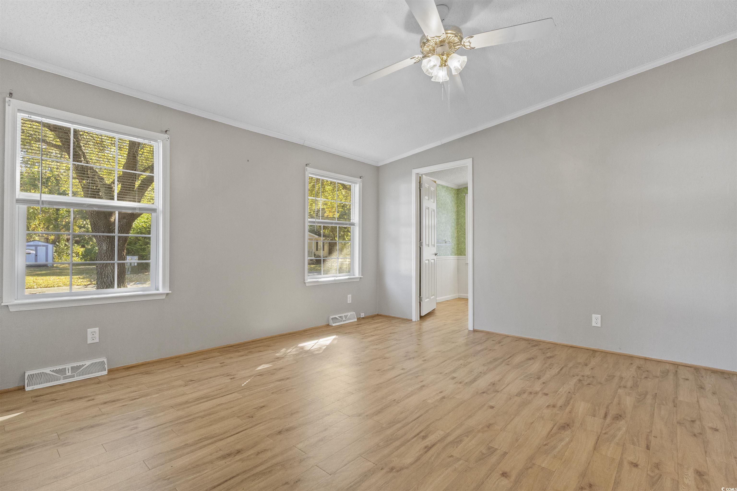 48 Talon Circle Murrells Inlet, SC 29576 - Photo 23 of 28 Spare room featuring light wood-style floors, crown molding, vaulted ceiling, a textured ceiling, and a ceiling fan