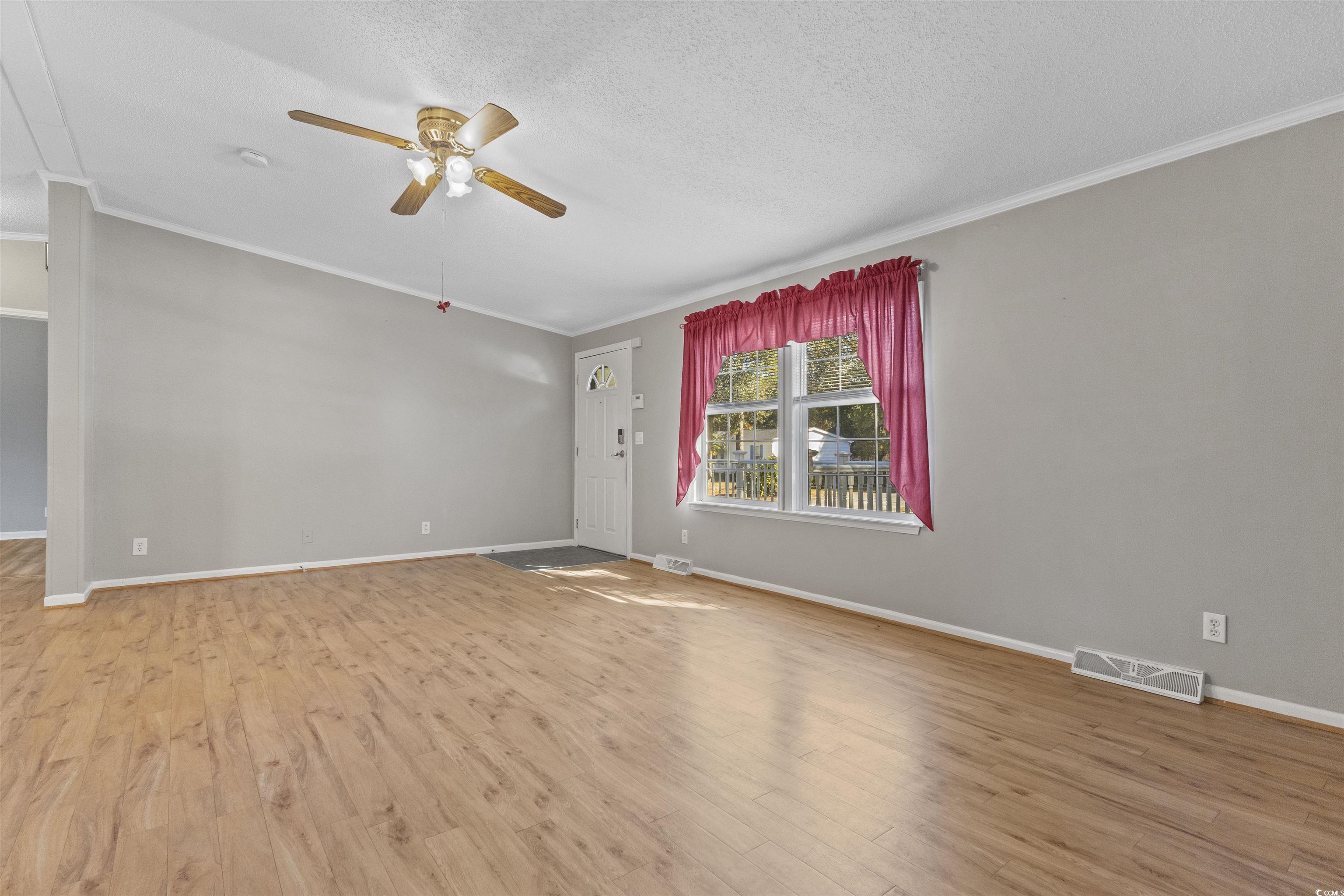 48 Talon Circle Murrells Inlet, SC 29576 - Photo 24 of 28 Unfurnished room featuring crown molding, light wood-style floors, a textured ceiling, and ceiling fan