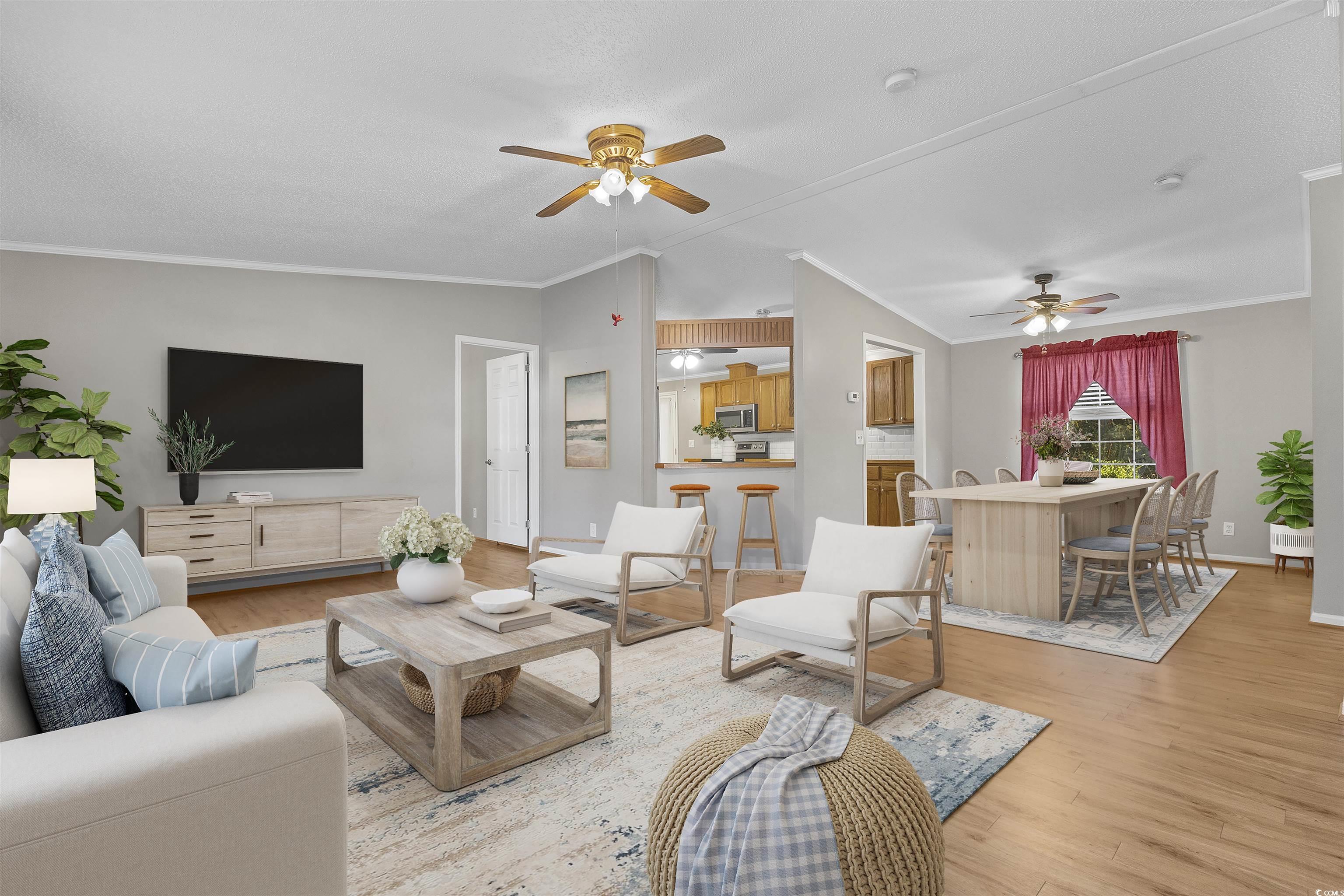 48 Talon Circle Murrells Inlet, SC 29576 - Photo 5 of 28 Living area with lofted ceiling, crown molding, wood finished floors, and ceiling fan