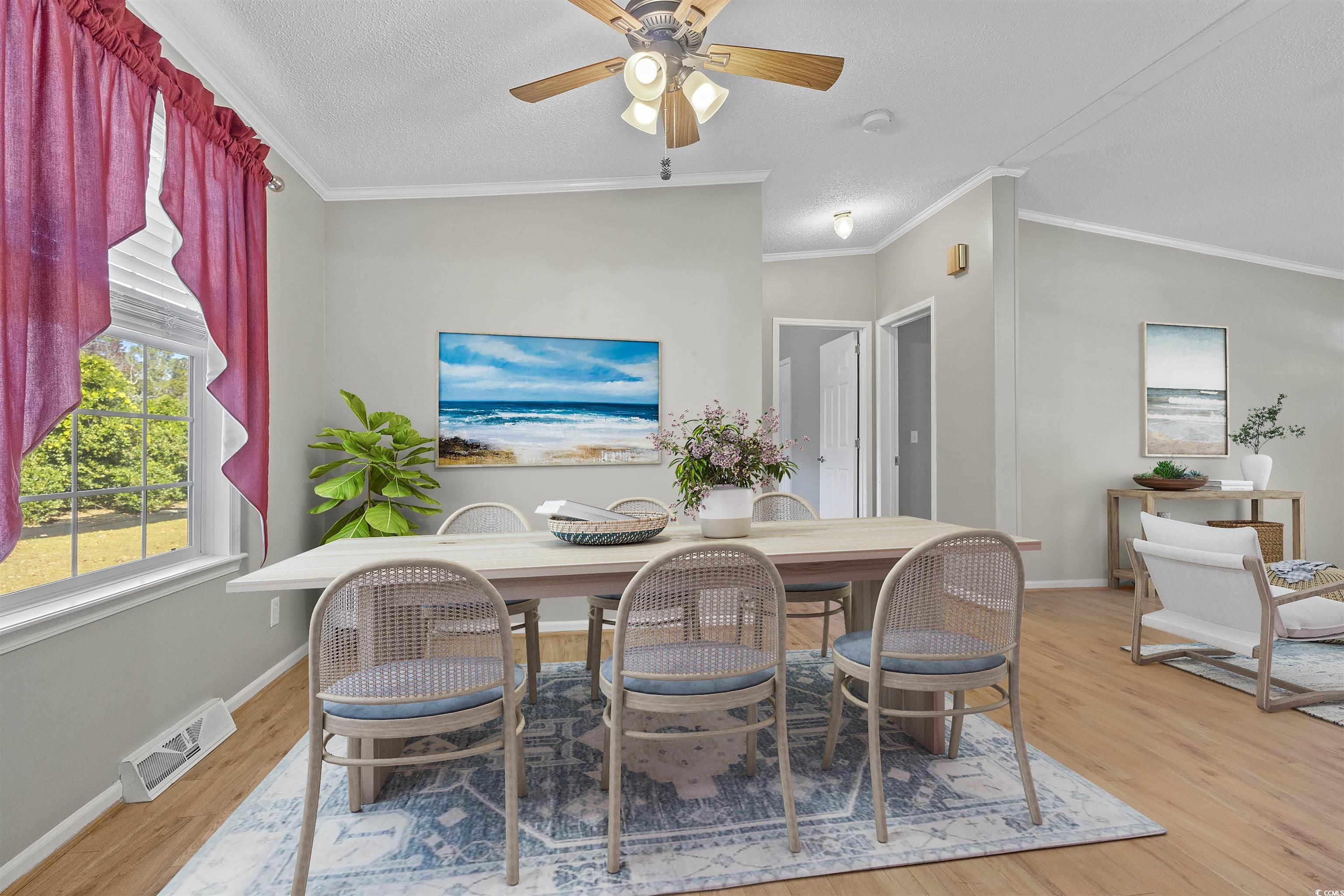 48 Talon Circle Murrells Inlet, SC 29576 - Photo 7 of 28 Dining area featuring crown molding, light wood-style floors, a ceiling fan, and a textured ceiling
