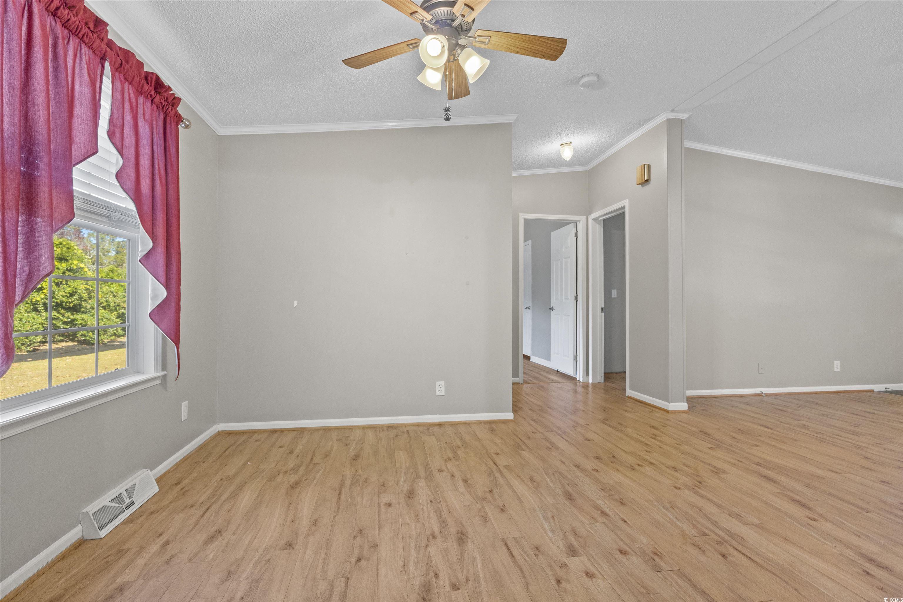 48 Talon Circle Murrells Inlet, SC 29576 - Photo 8 of 28 Spare room featuring light wood-type flooring, ornamental molding, ceiling fan, and a textured ceiling