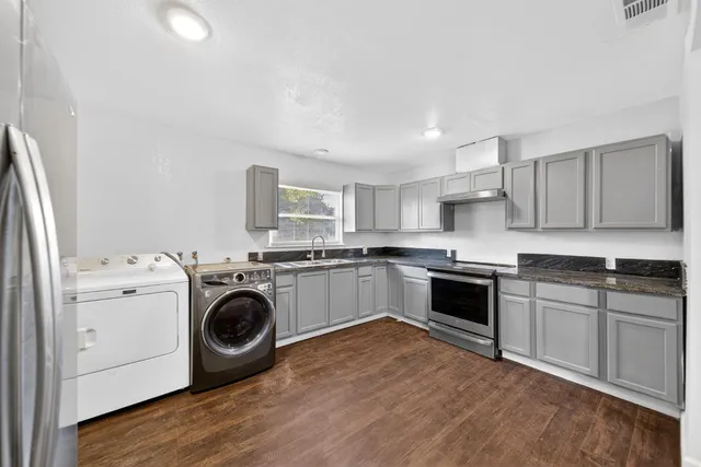 a kitchen with a stove top oven sink and cabinets