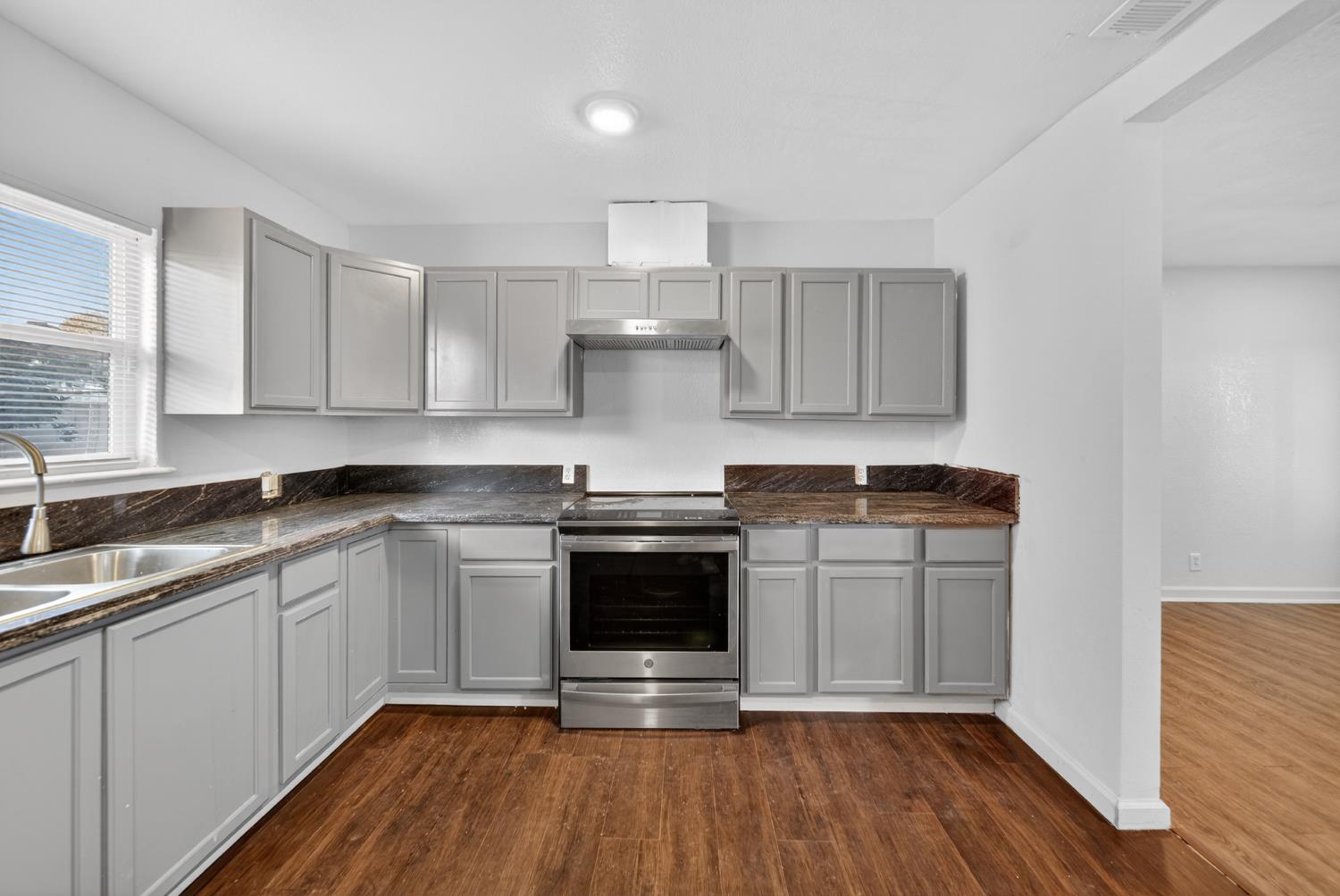 622 South 11th Street Fresno, CA 93702 - Photo 21 of 37 a kitchen with stainless steel appliances granite countertop a stove and white cabinets