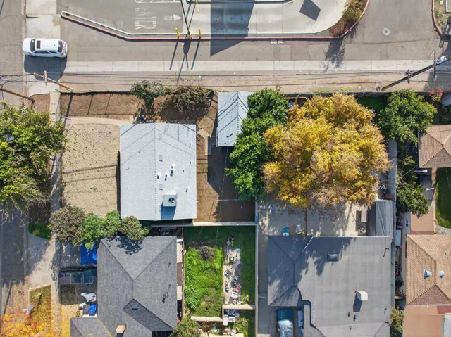 an aerial view of a house with a yard and large trees