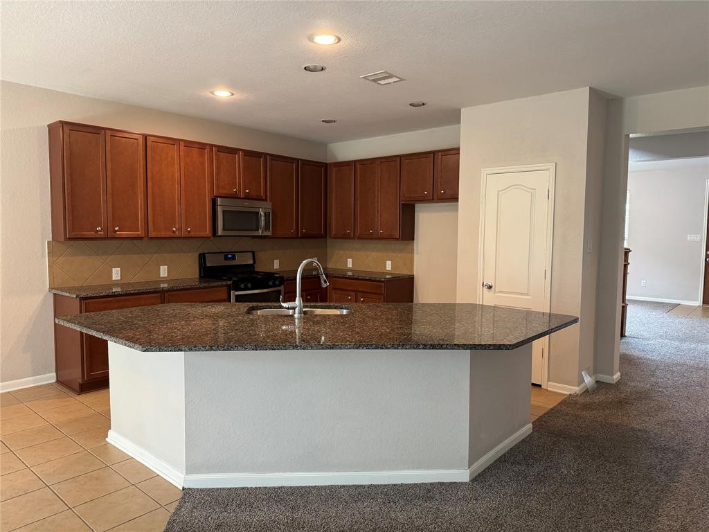 2818 Mezzomonte Lane League City, TX 77573 - Photo 2 of 13 a kitchen with granite countertop a sink a stove and cabinets