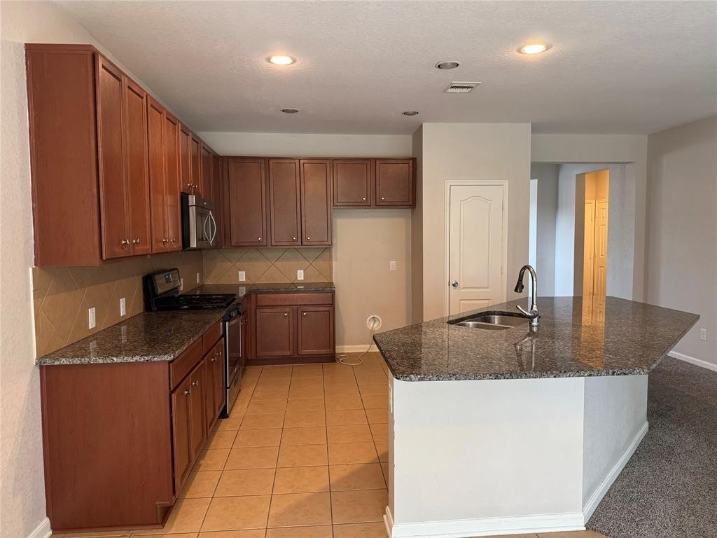 2818 Mezzomonte Lane League City, TX 77573 - Photo 3 of 13 a kitchen with stainless steel appliances granite countertop a sink stove and refrigerator