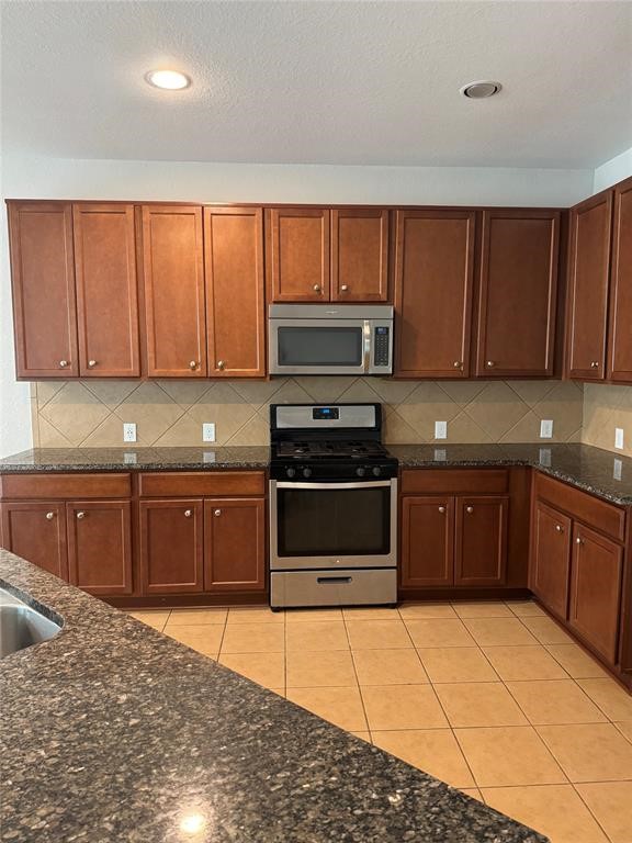 2818 Mezzomonte Lane League City, TX 77573 - Photo 4 of 13 a kitchen with stainless steel appliances granite countertop a stove a sink and a microwave