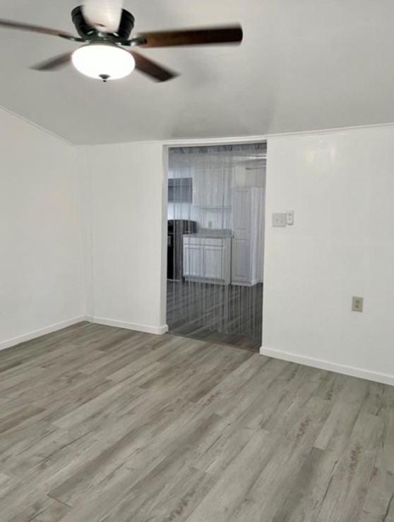516 Sodville Street Sinton, TX 78387 - Photo 8 of 11 an empty room with wooden floor cabinet and windows