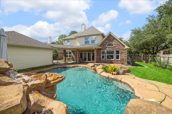 a view of a house with a swimming pool and a yard