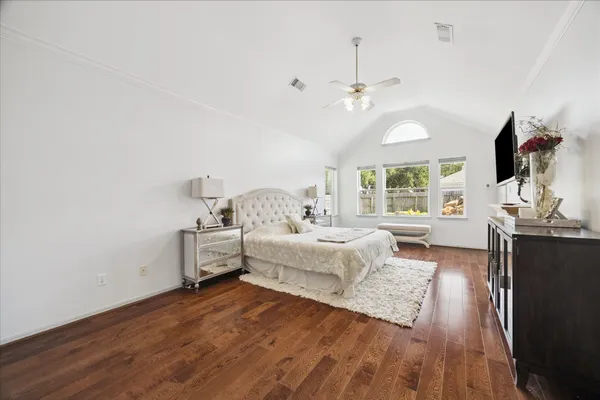 a spacious bedroom with a bed and a flat screen tv
