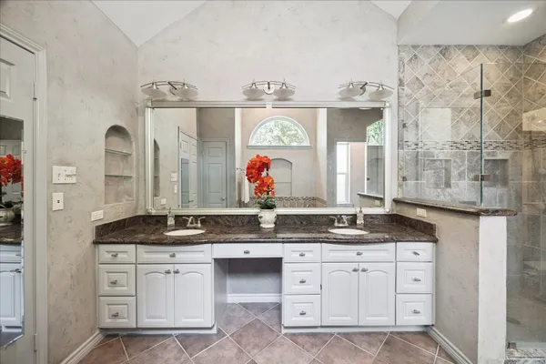 a bathroom with a granite countertop sink and a mirror