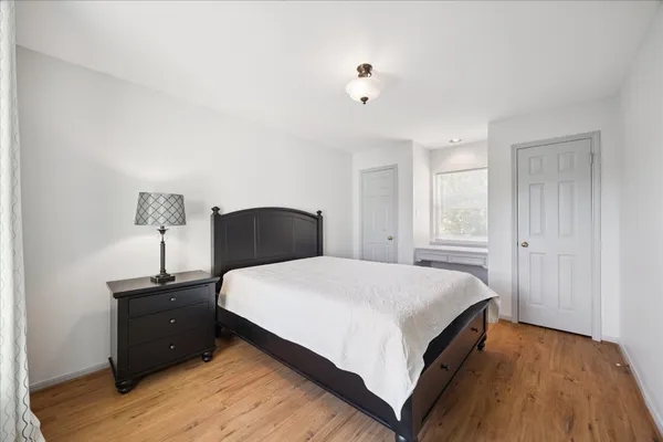 a bedroom with a bed and wooden floor