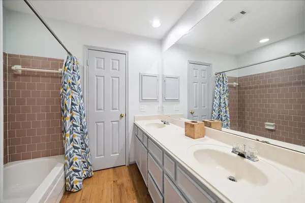 a bathroom with a double vanity sink mirror and shower