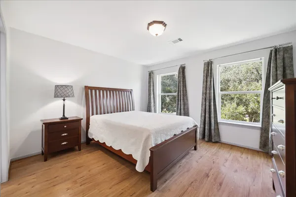 a bed sitting in a spacious bedroom next to a window