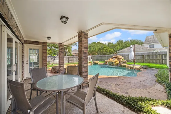 a view of a patio with a table chairs and a backyard