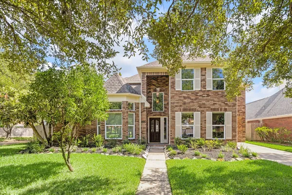 front view of a brick house with a yard
