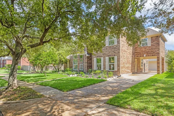 a front view of a house with a yard and trees