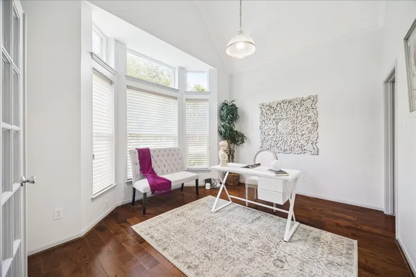 a work room with furniture wooden floor and windows