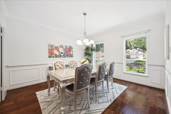 a dining room with furniture a window and wooden floor
