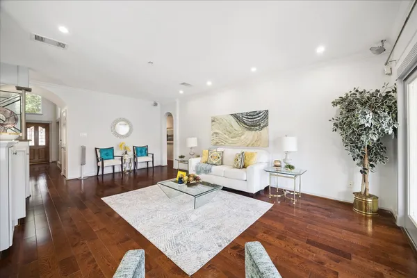 a living room with furniture and a wooden floor