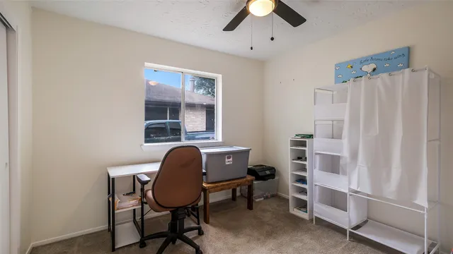 a view of a workspace with furniture and a window