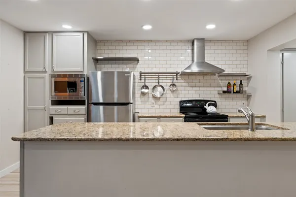 a kitchen with stainless steel appliances granite countertop a stove and a sink