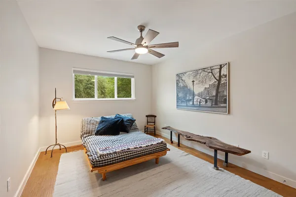 a bedroom with a bed and wooden floor
