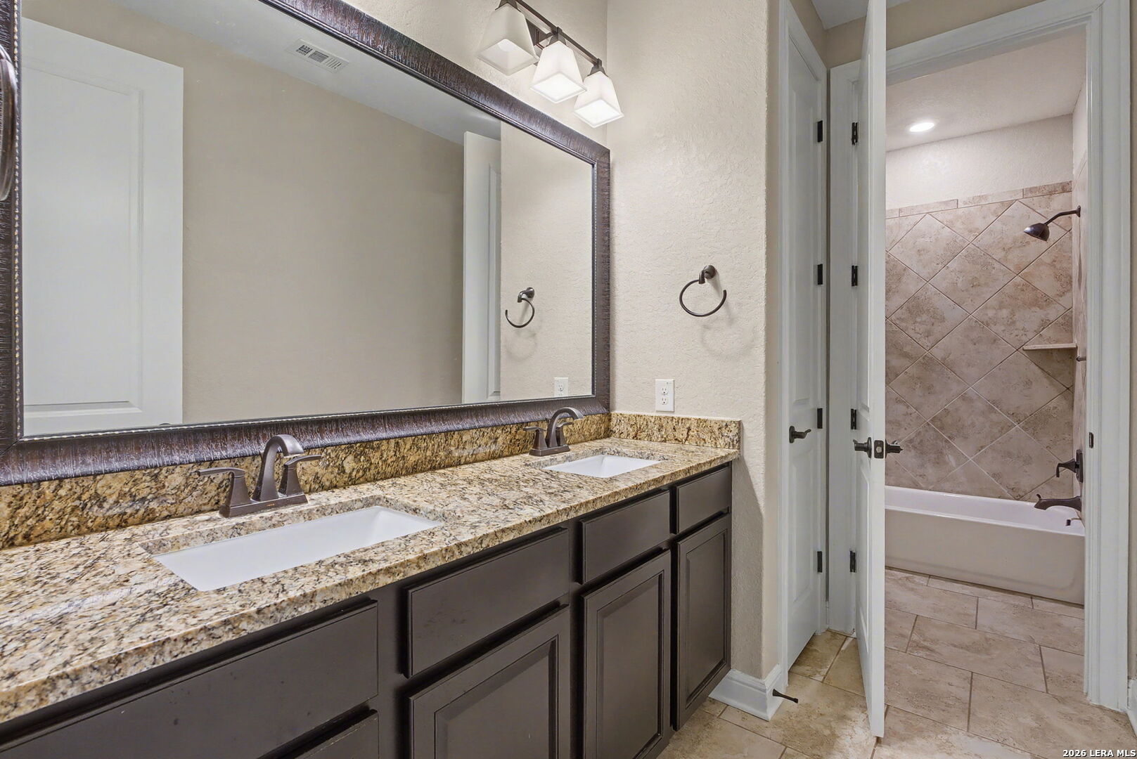 269 Big Bend Path Castroville, TX 78009 - Photo 23 of 42 a bathroom with a granite countertop sink and a mirror