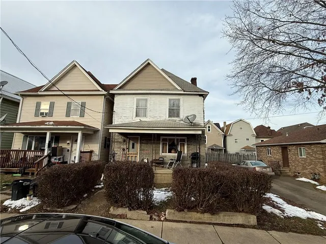 a front view of a house with yard and parking