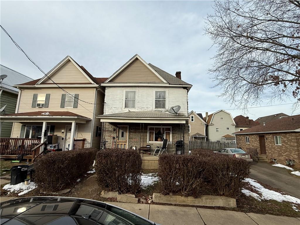 a front view of a house with yard and parking